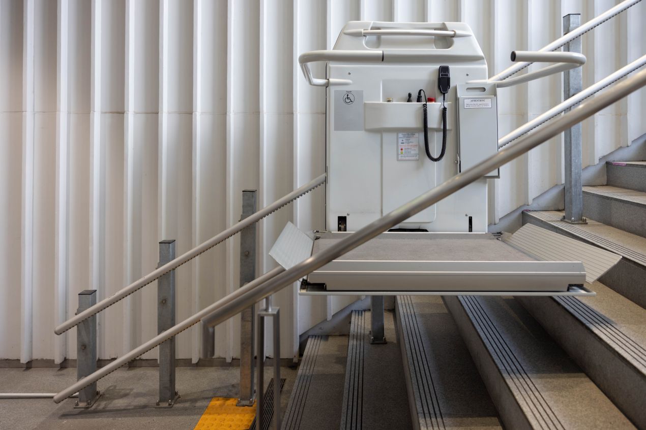 Installierter Treppenlift mit Plattform an einer Innentreppe für barrierefreien Zugang in öffentlichen Gebäuden