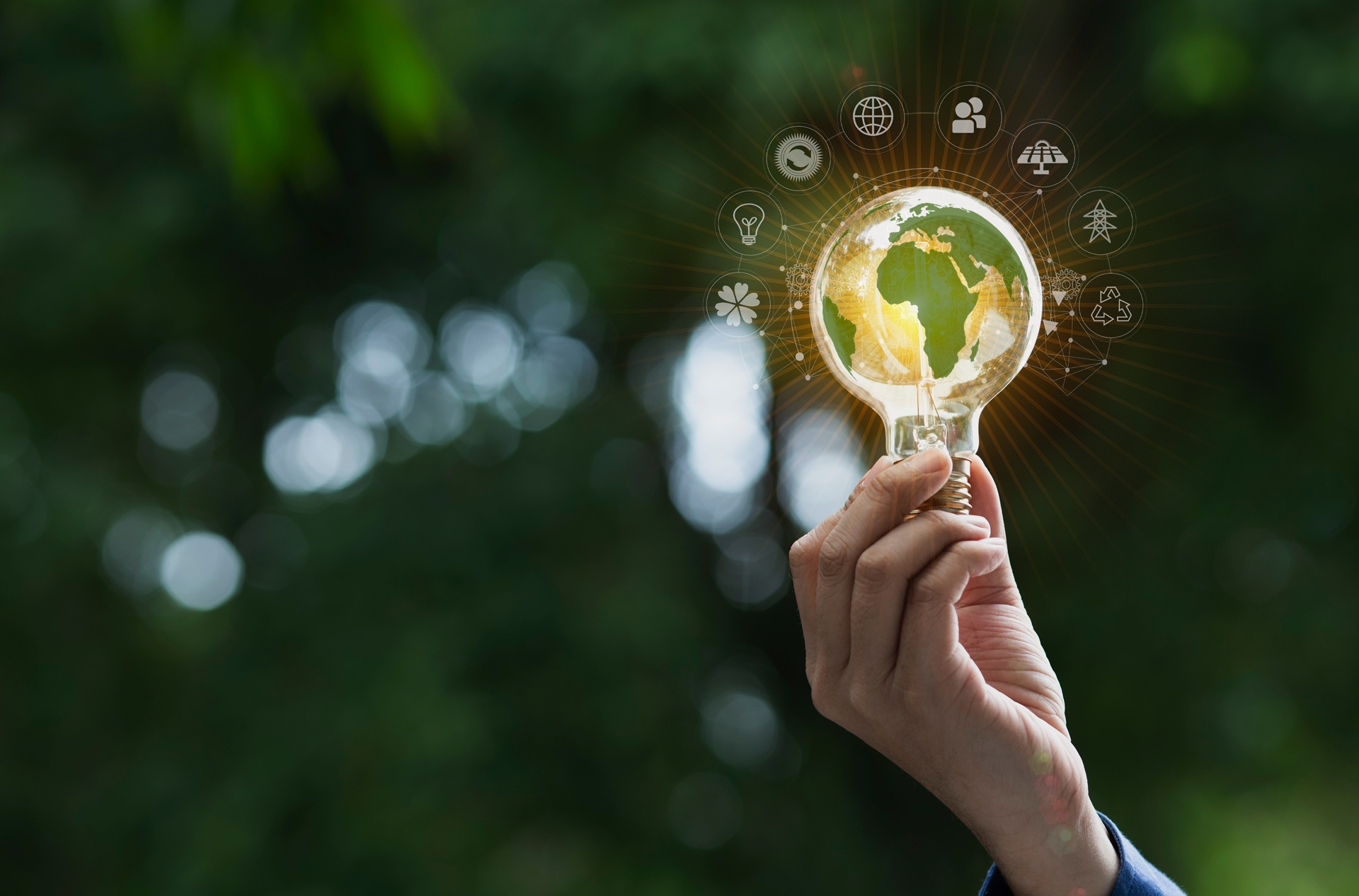Hand hält Glühbirne mit Weltkarte als Symbol für Nachhaltigkeit | umweltgerechte Straßenreparatur